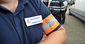 Photo of a search and report officer with a zoom on his armband